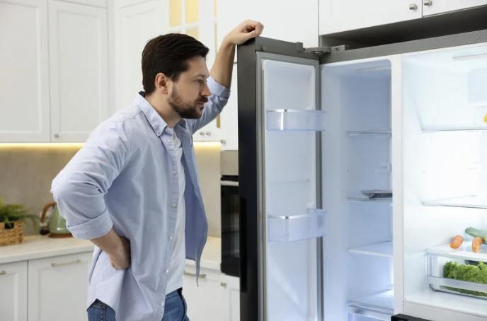 man looking into refrigerator