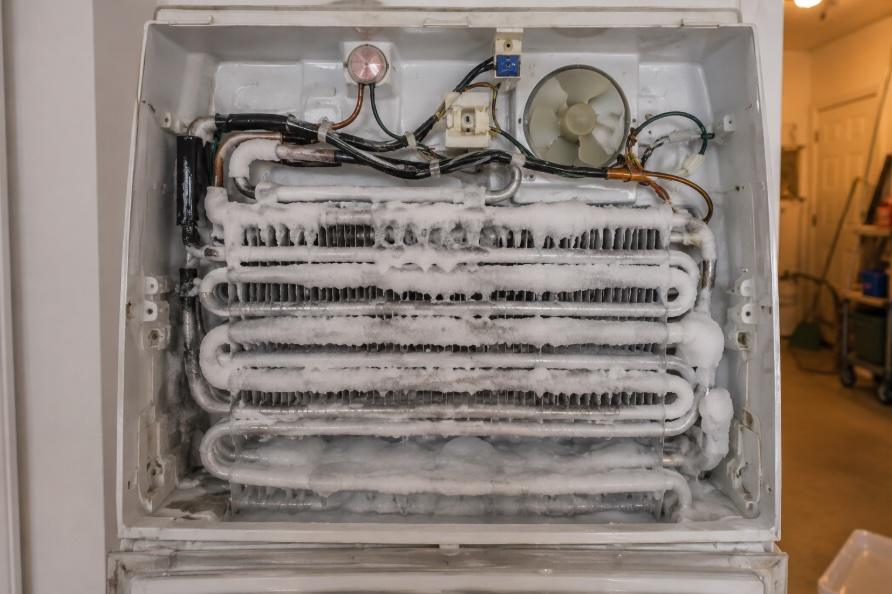 Frozen evaporator coils inside a residential refrigerator causing cooling failure
